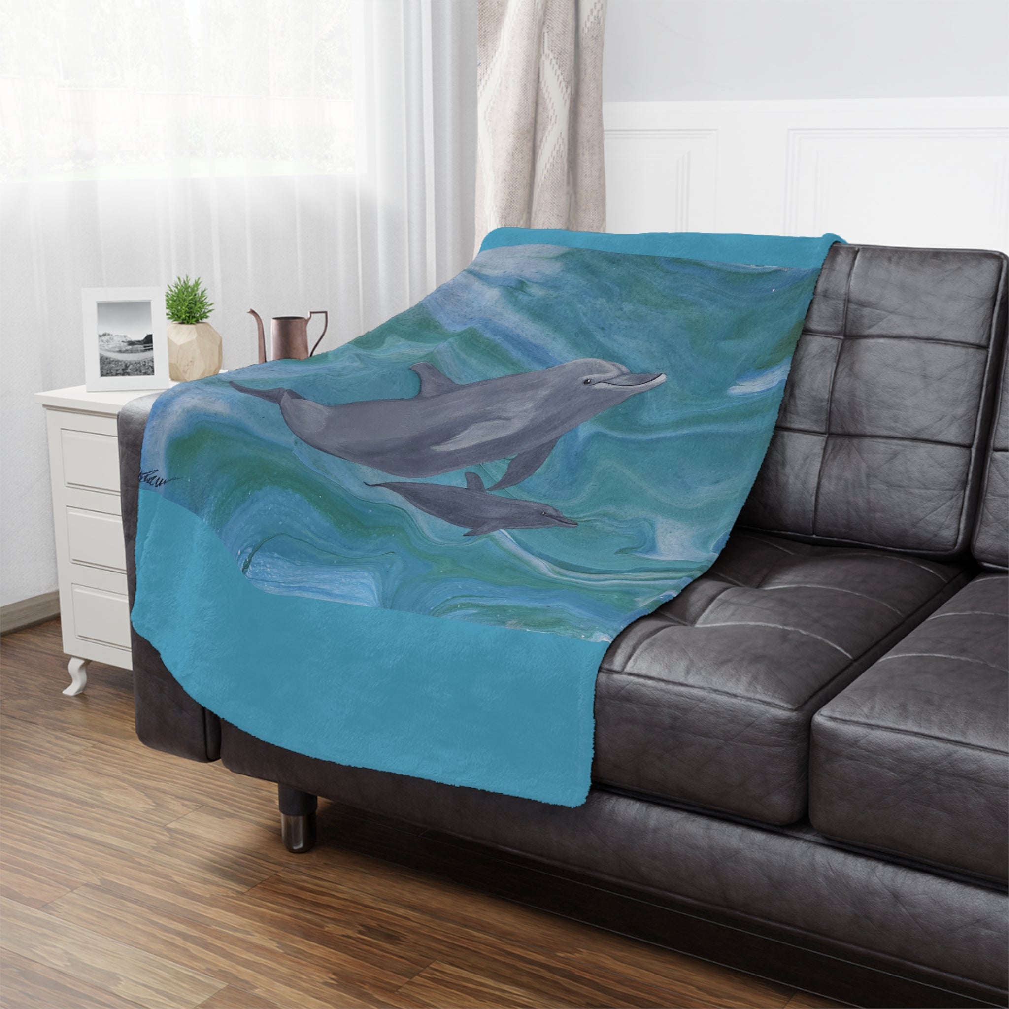 Blanket on couch with image of Dolphin and baby swimming in turquoise sea