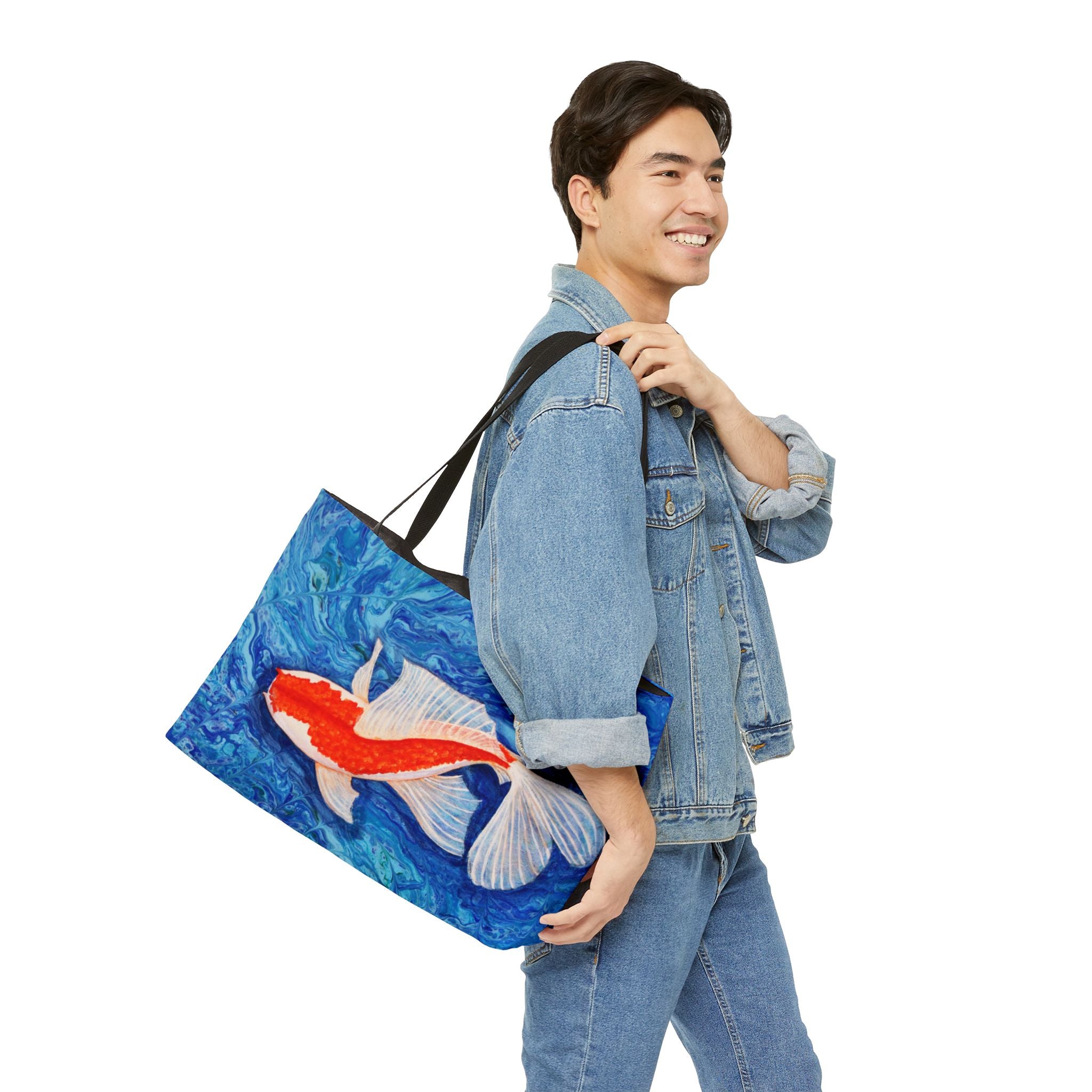 Person carrying a tote bag with a fish design on a white background
