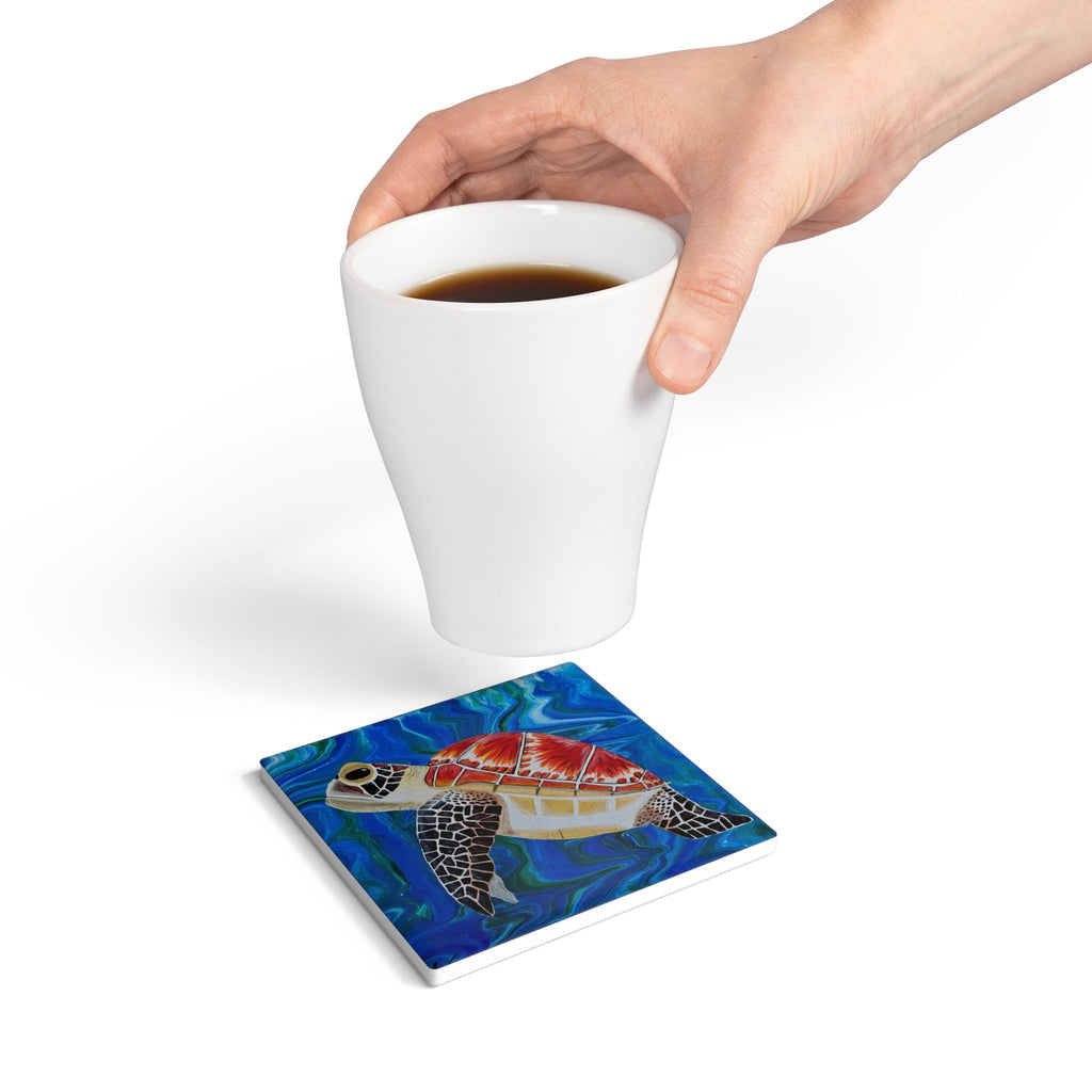 Coaster with turtle design under a white cup of coffee on a white background