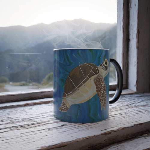 Mug with a turtle design on a windowsill with a mountain view