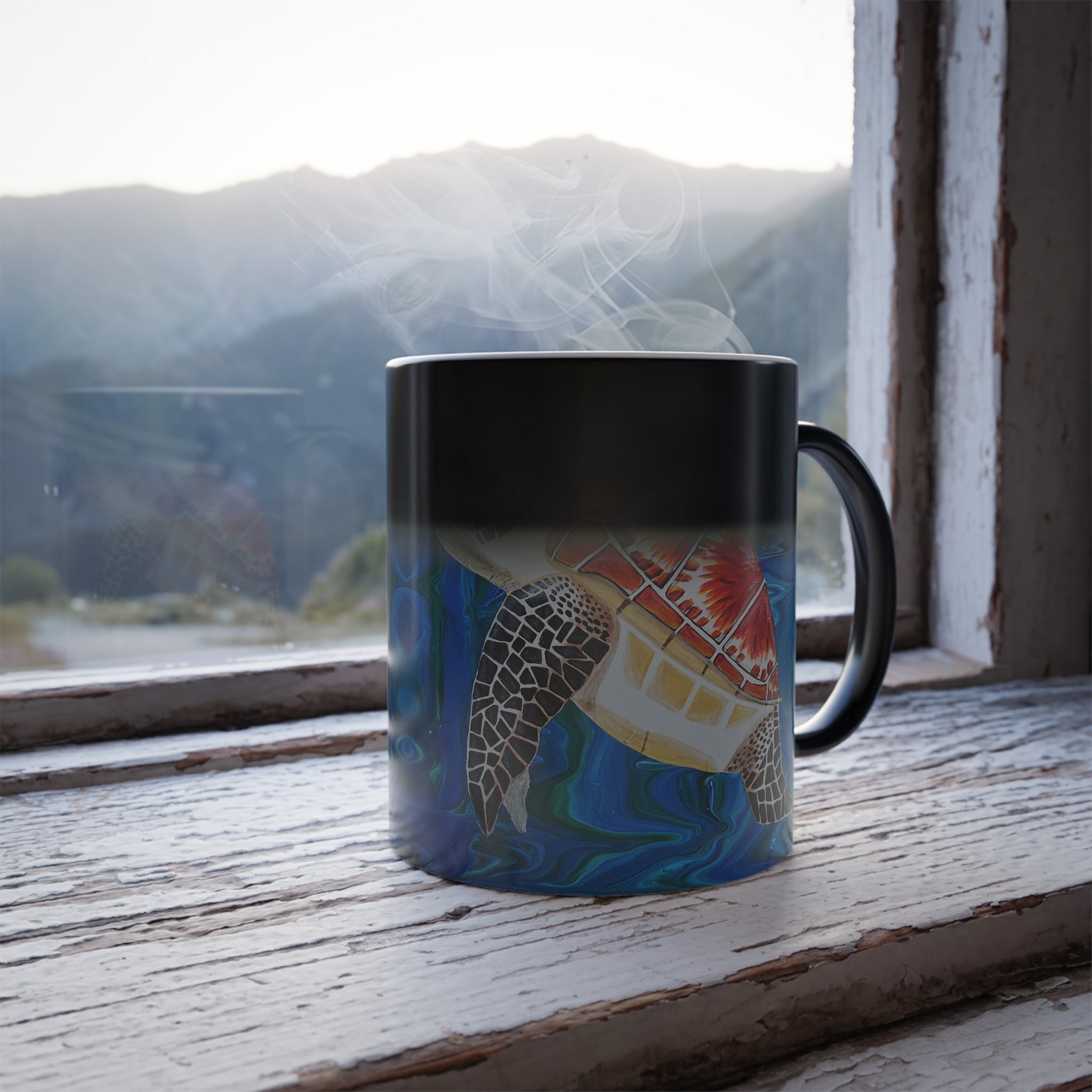 Mug with a turtle design on a windowsill with a mountain view