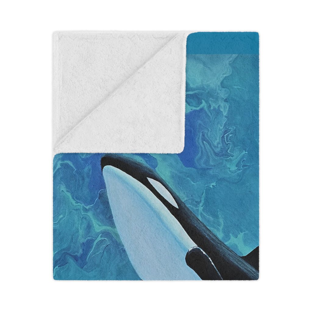 Orca whale design on a blue and white background blanket folded