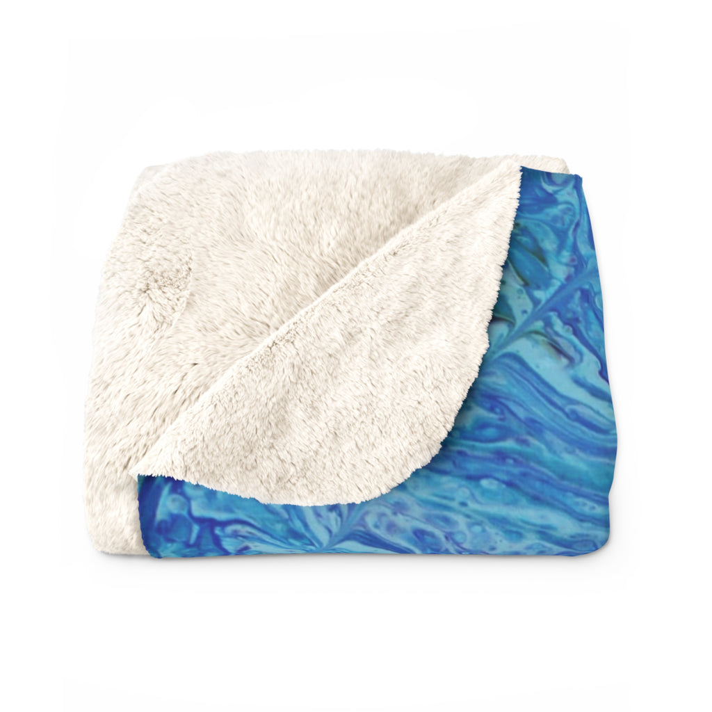 Blanket with blue marbled pattern and white sherpa fleece on a white background