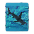 Blanket with a shark design on a blue and green abstract pattern
