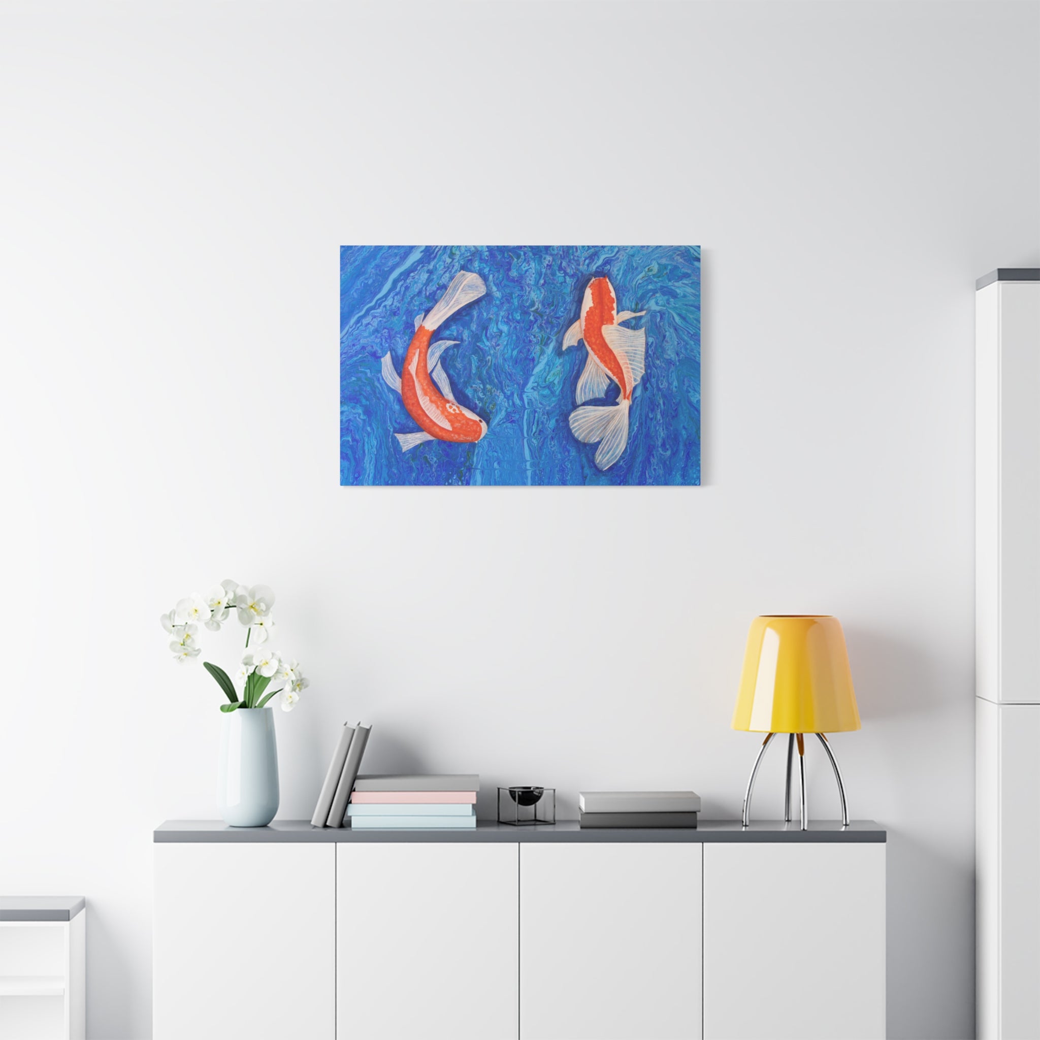 Decorative painting of koi fish on a wall above a white cabinet with a yellow lamp.