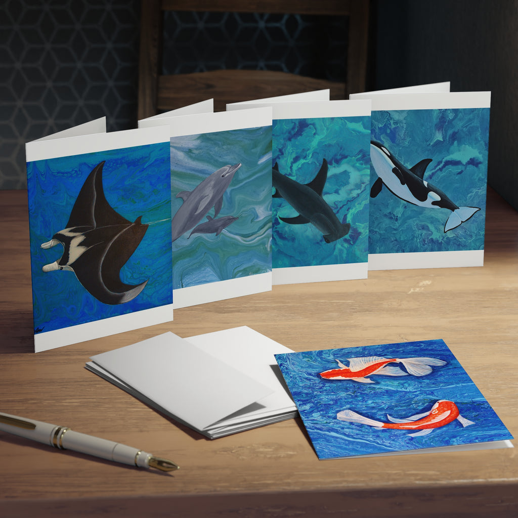 Set of greeting cards with ocean-themed illustrations on a wooden surface.