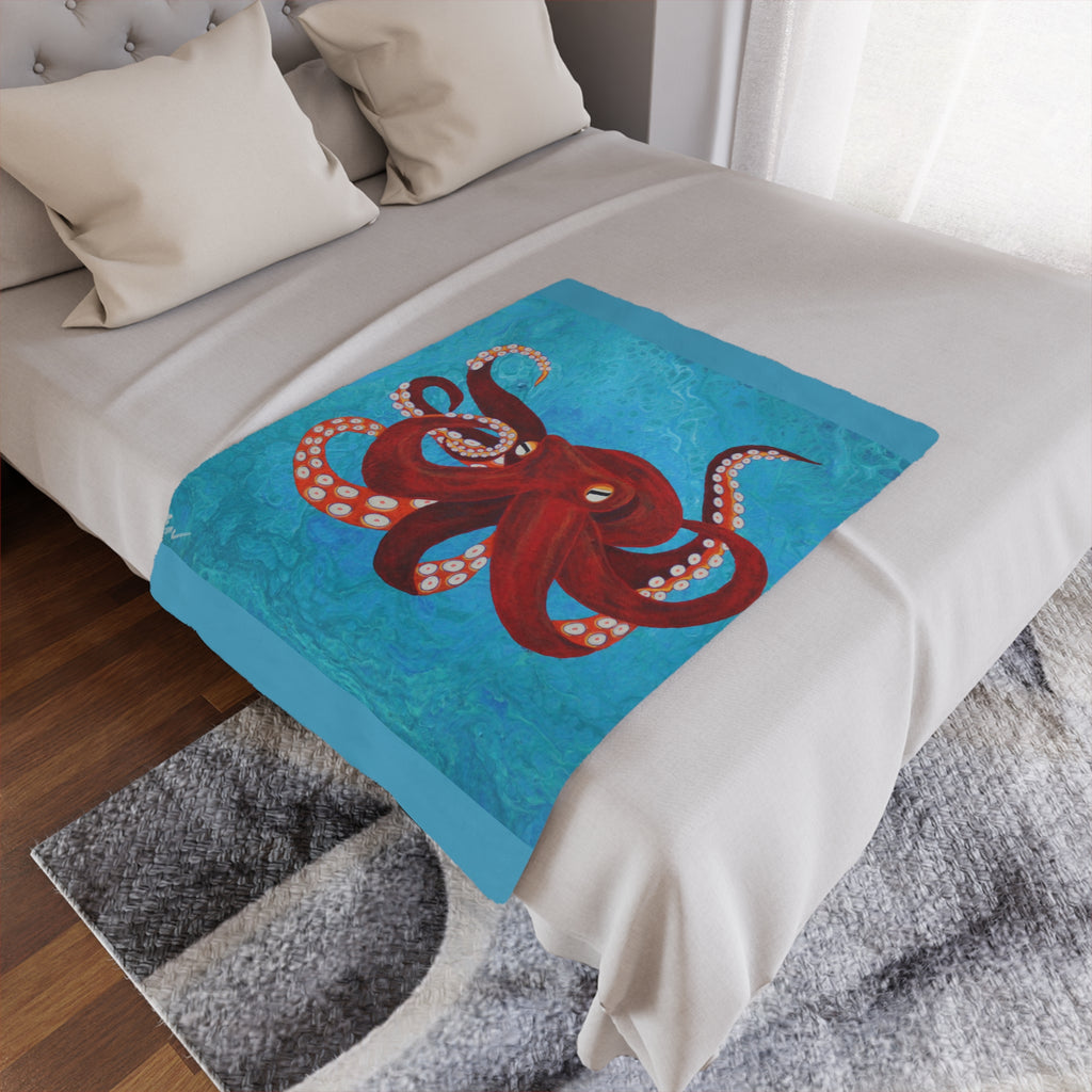Bed with a decorative blanket featuring an octopus design on a blue background.