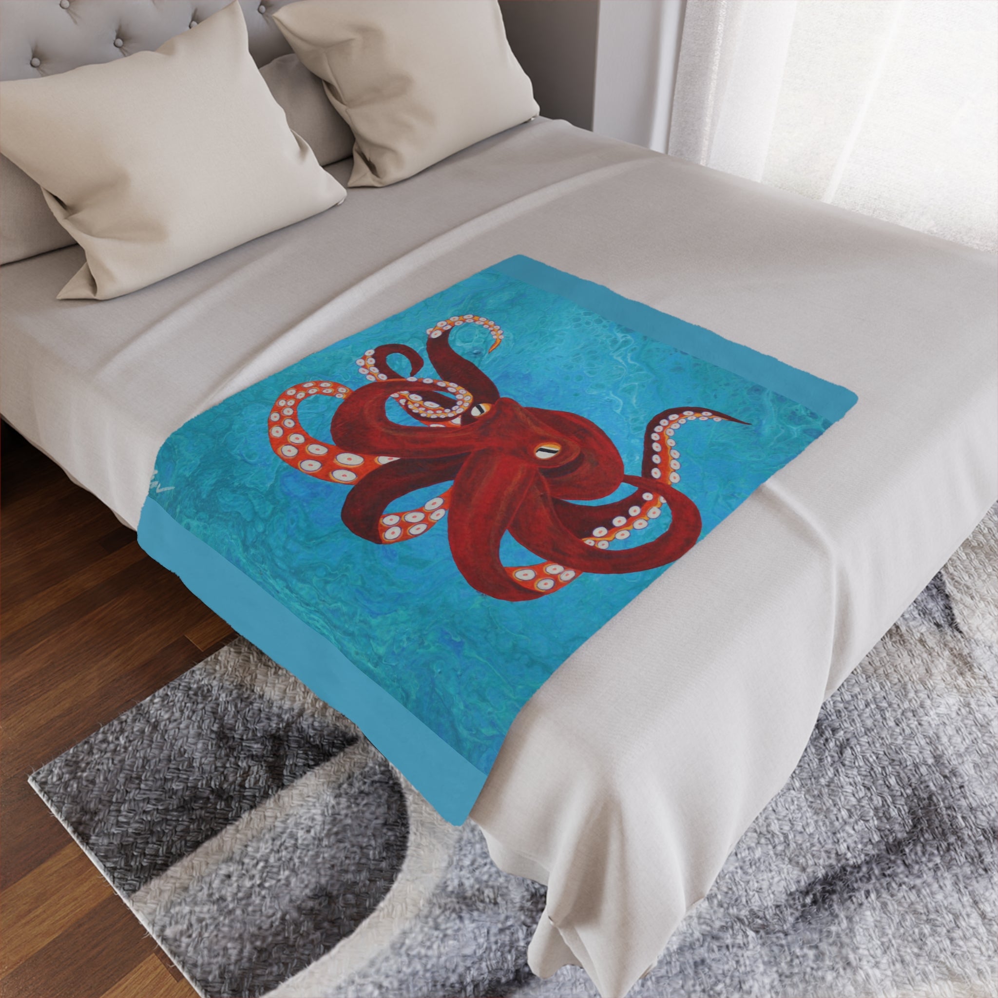 Bed with a decorative blanket featuring an octopus design on a blue background.