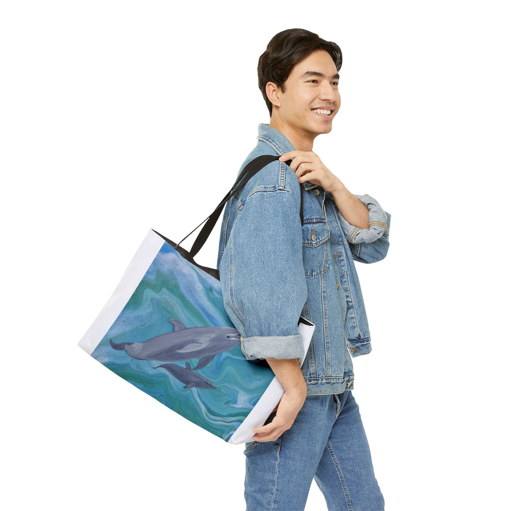 Man carrying a tote bag with a dolphin design on a white background