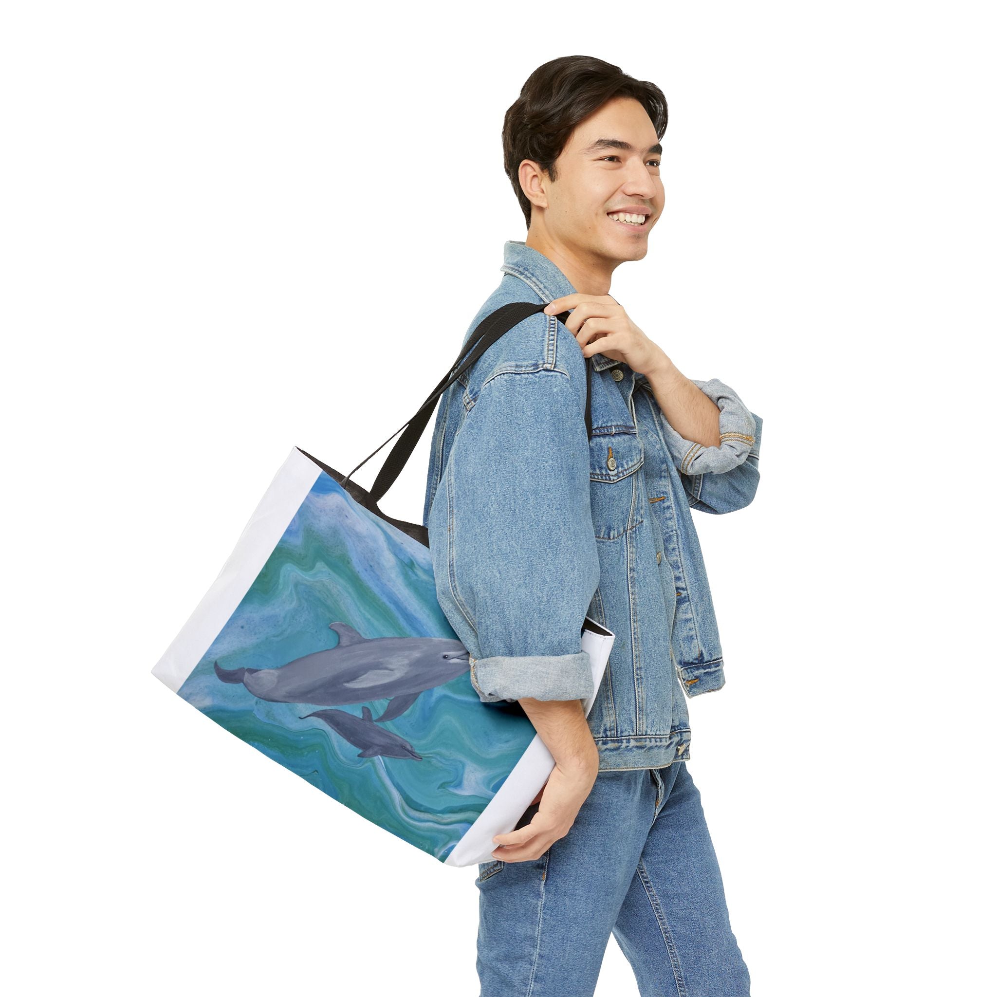 Man carrying a tote bag with a dolphin design on a white background