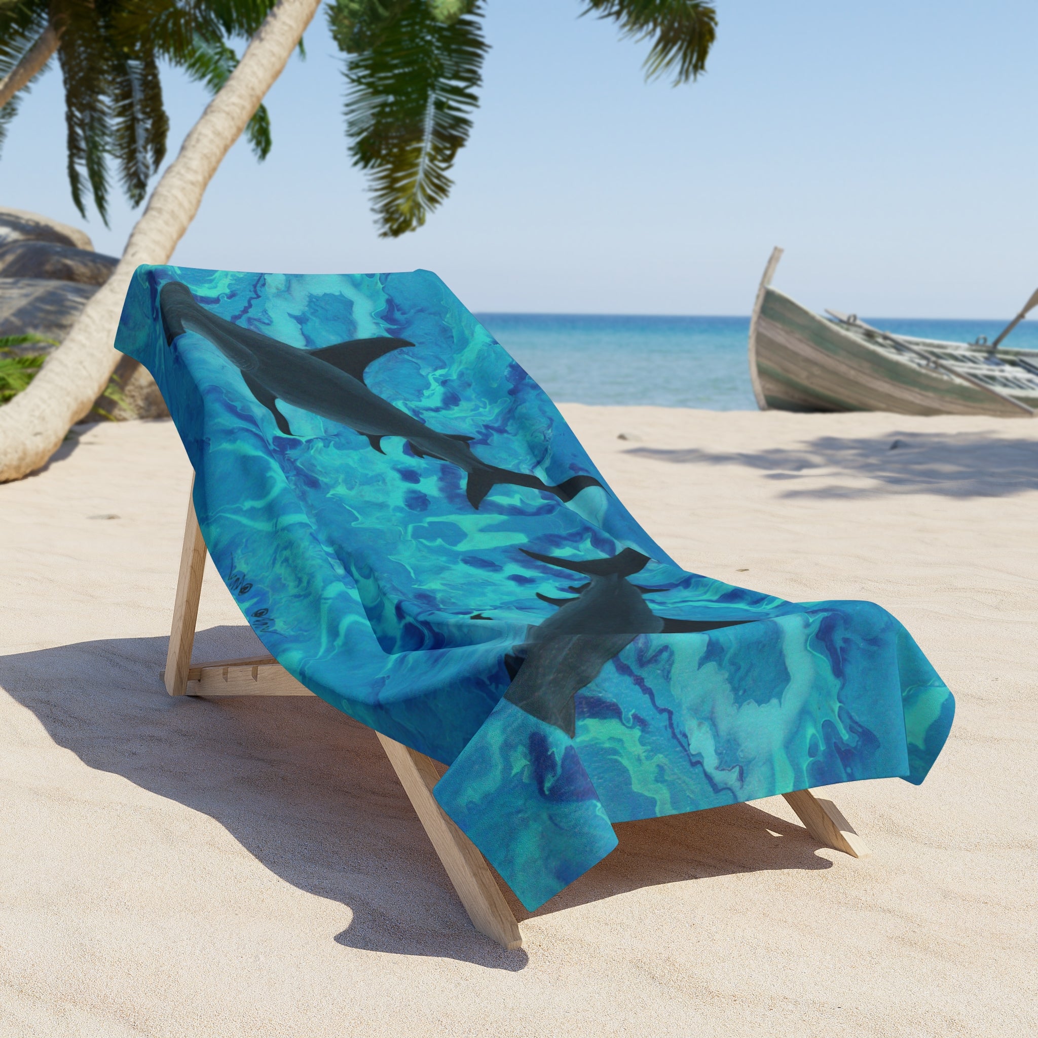 Beach towel/blanket with hammerhead shark design on a lounge chair at a beach.