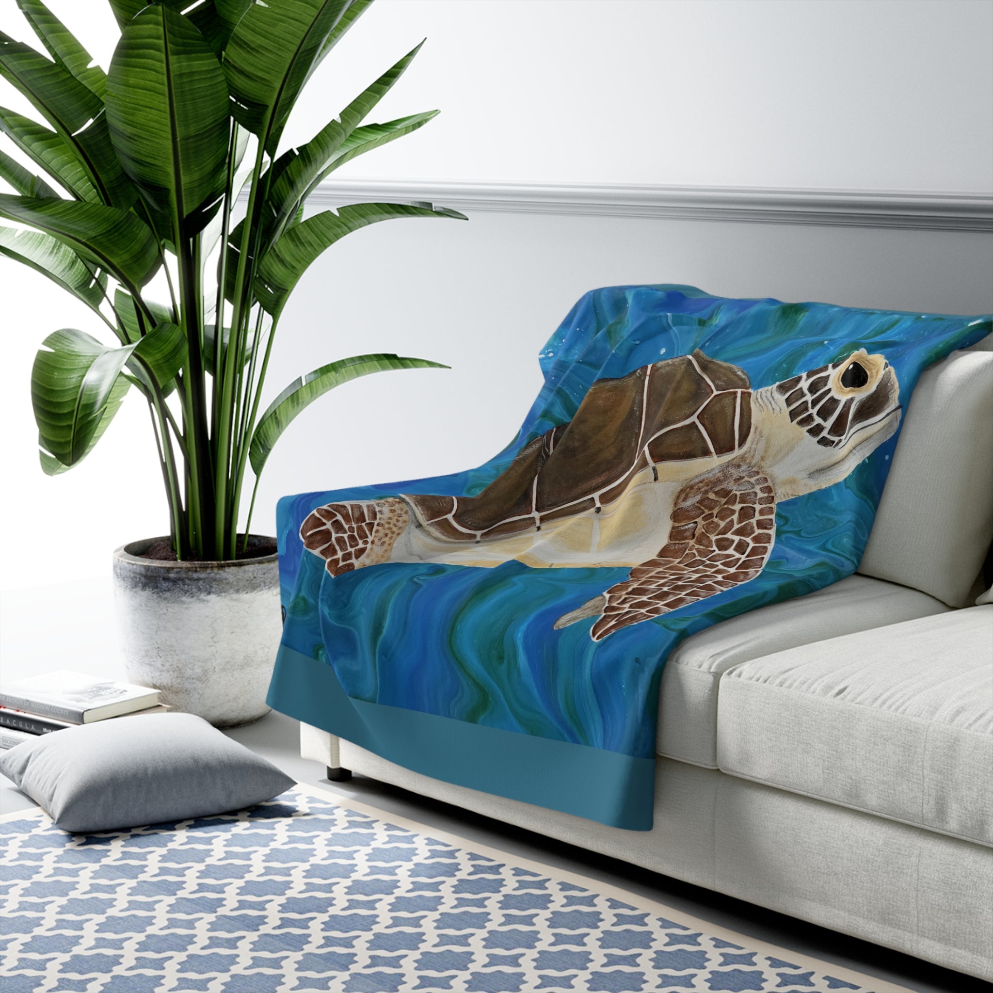 Sofa with a turtle-themed blanket draped over it in a living room setting.