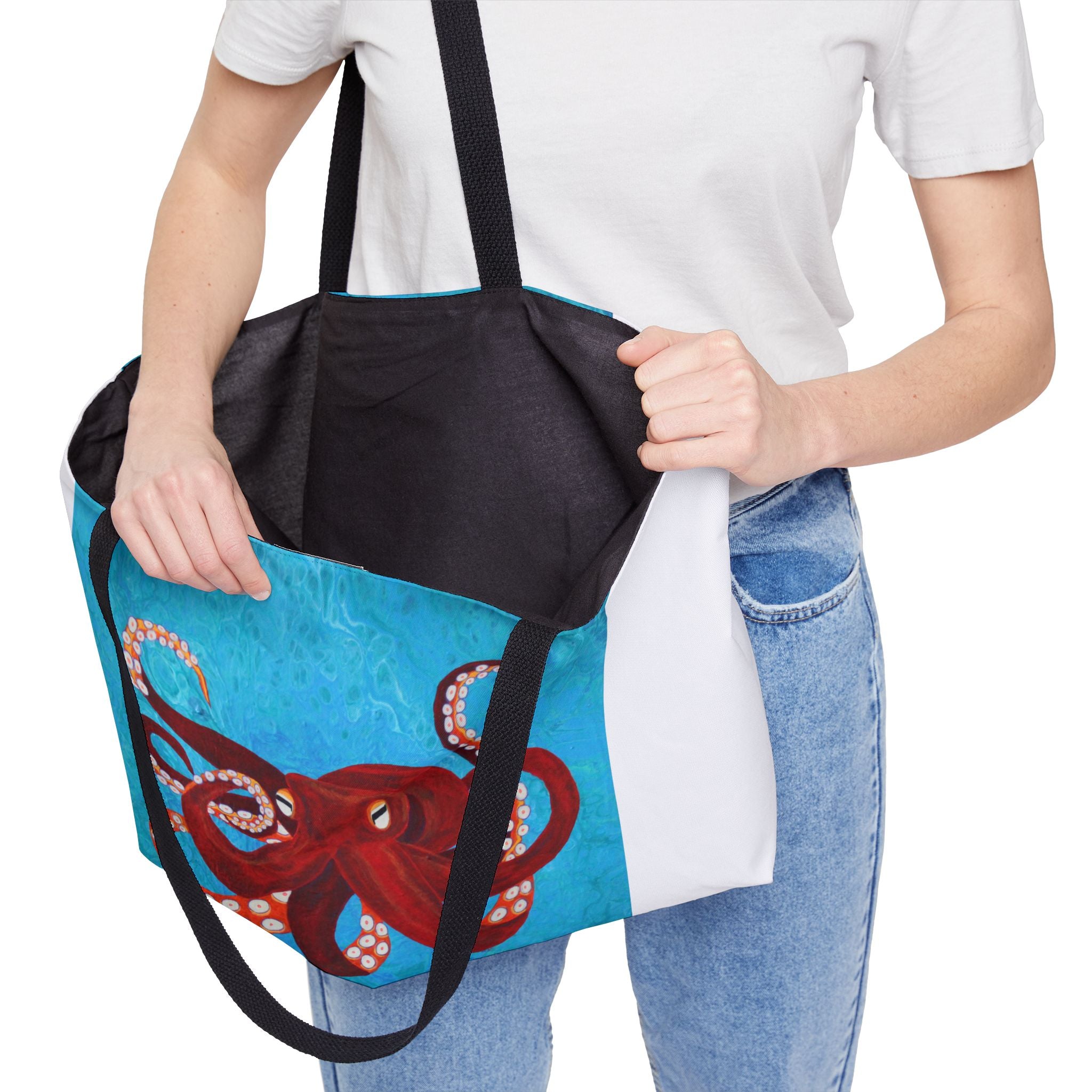 Person holding a tote bag with an octopus design on a white background