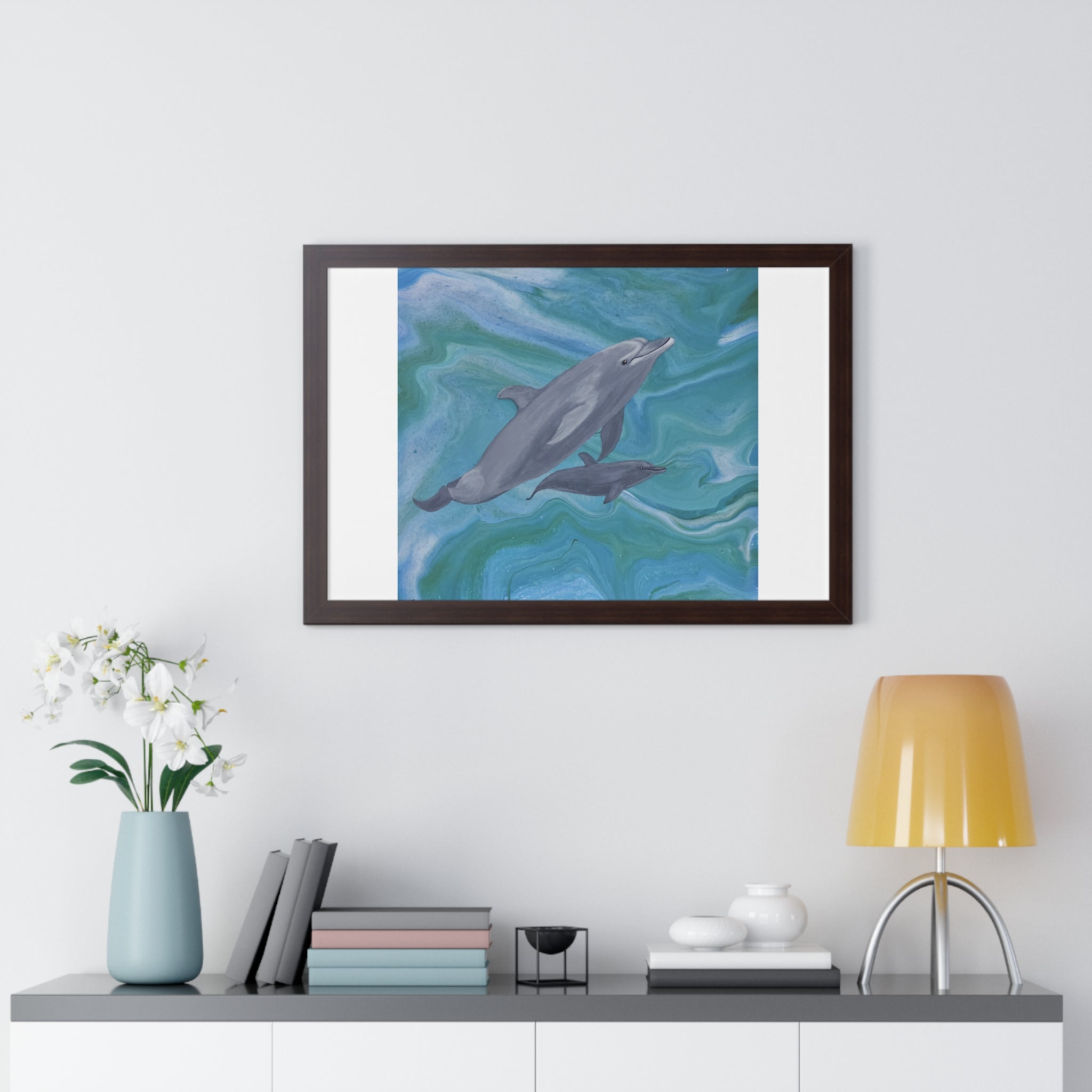 Framed artwork of dolphins on a wall above a shelf with decor items.