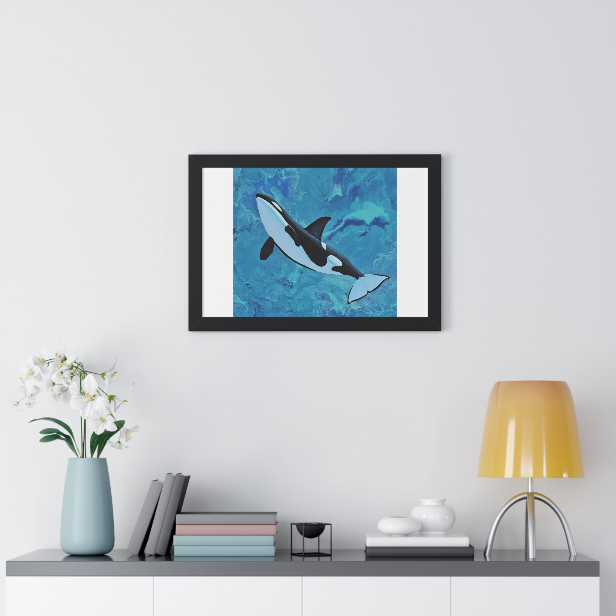 Framed artwork of a shark on a wall above a shelf with decor items.