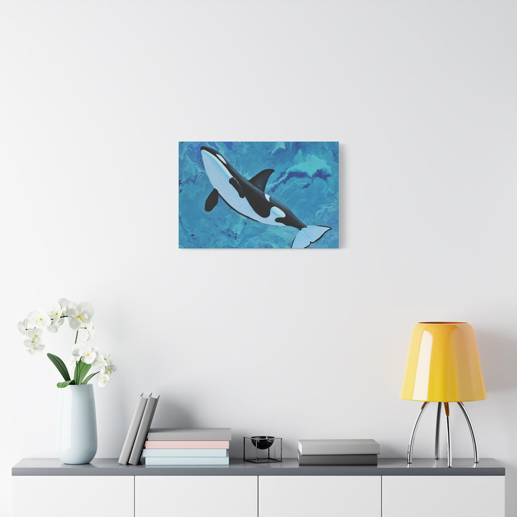 Orca whale painting on a wall above a shelf with decor items.