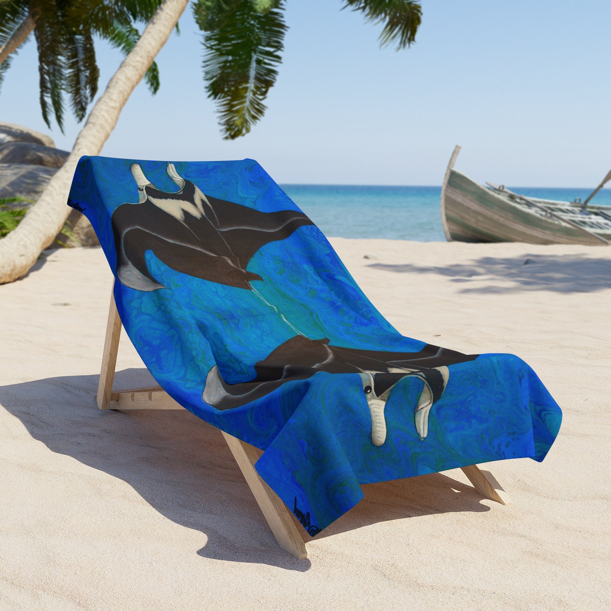 Blue towel/blanket with a manta ray design on a beach chair, palm trees, and ocean in the background.