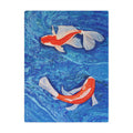 Two koi fish swimming in blue water on a blanket