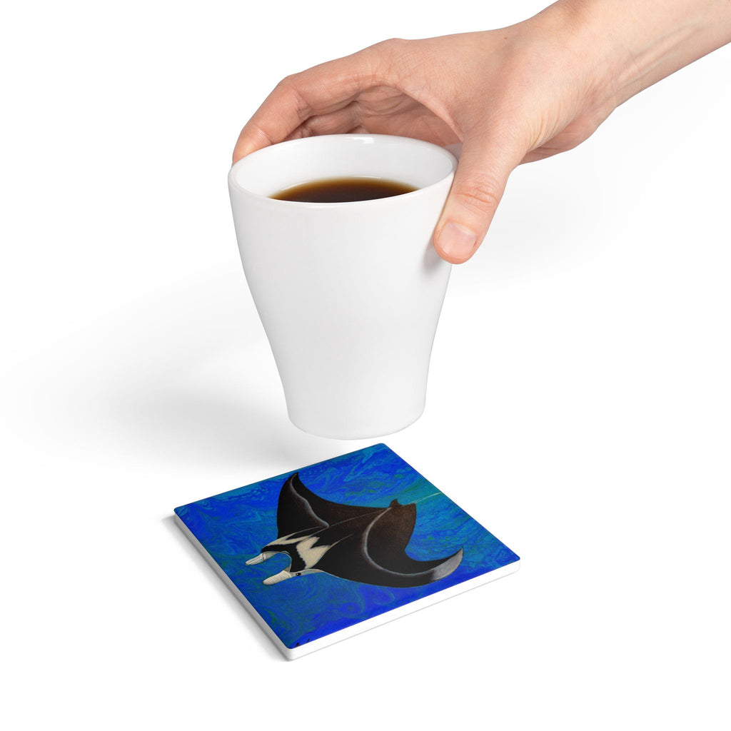 Coaster with manta ray design under a white cup of coffee