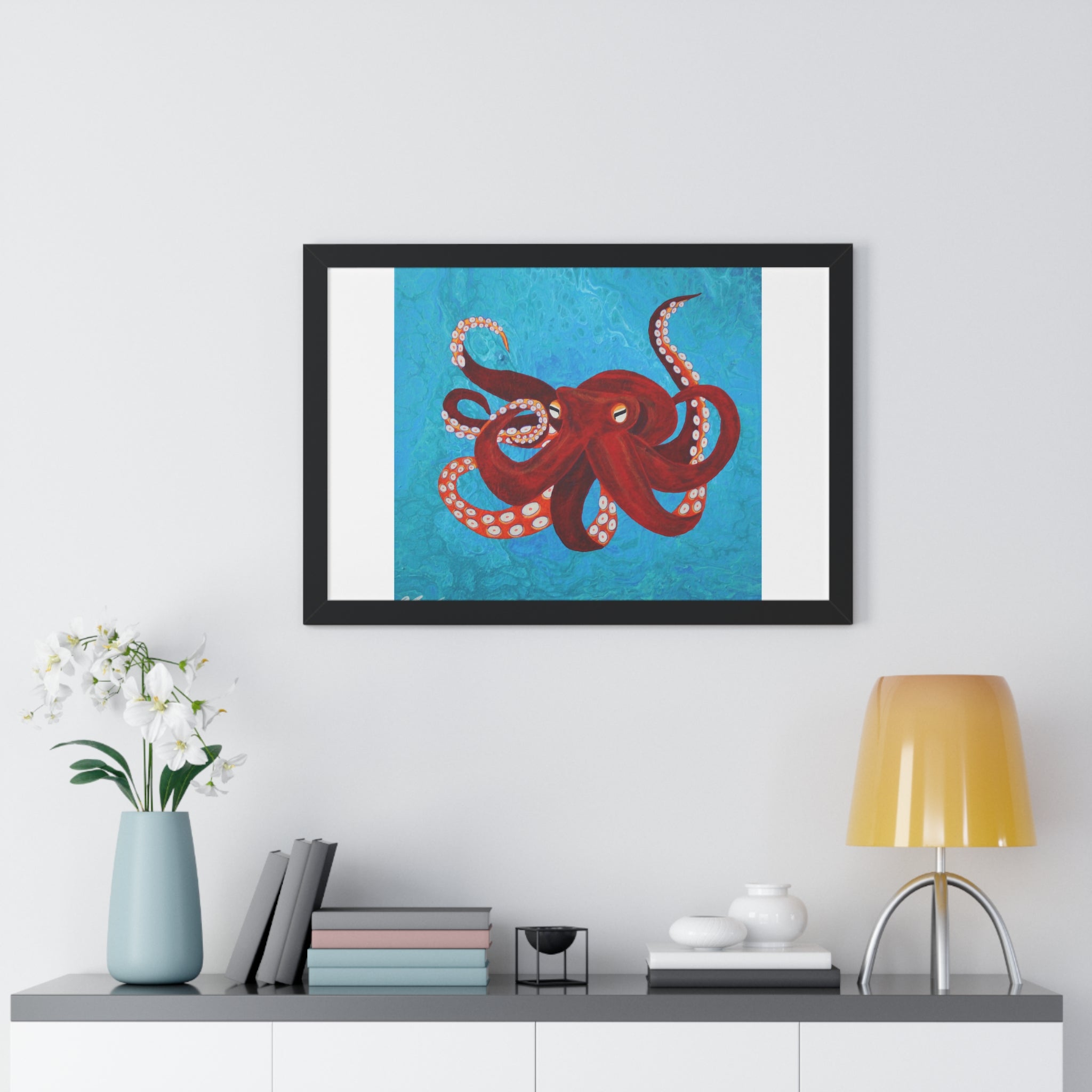 Framed artwork of a red octopus on a blue background above a shelf with decorative items.