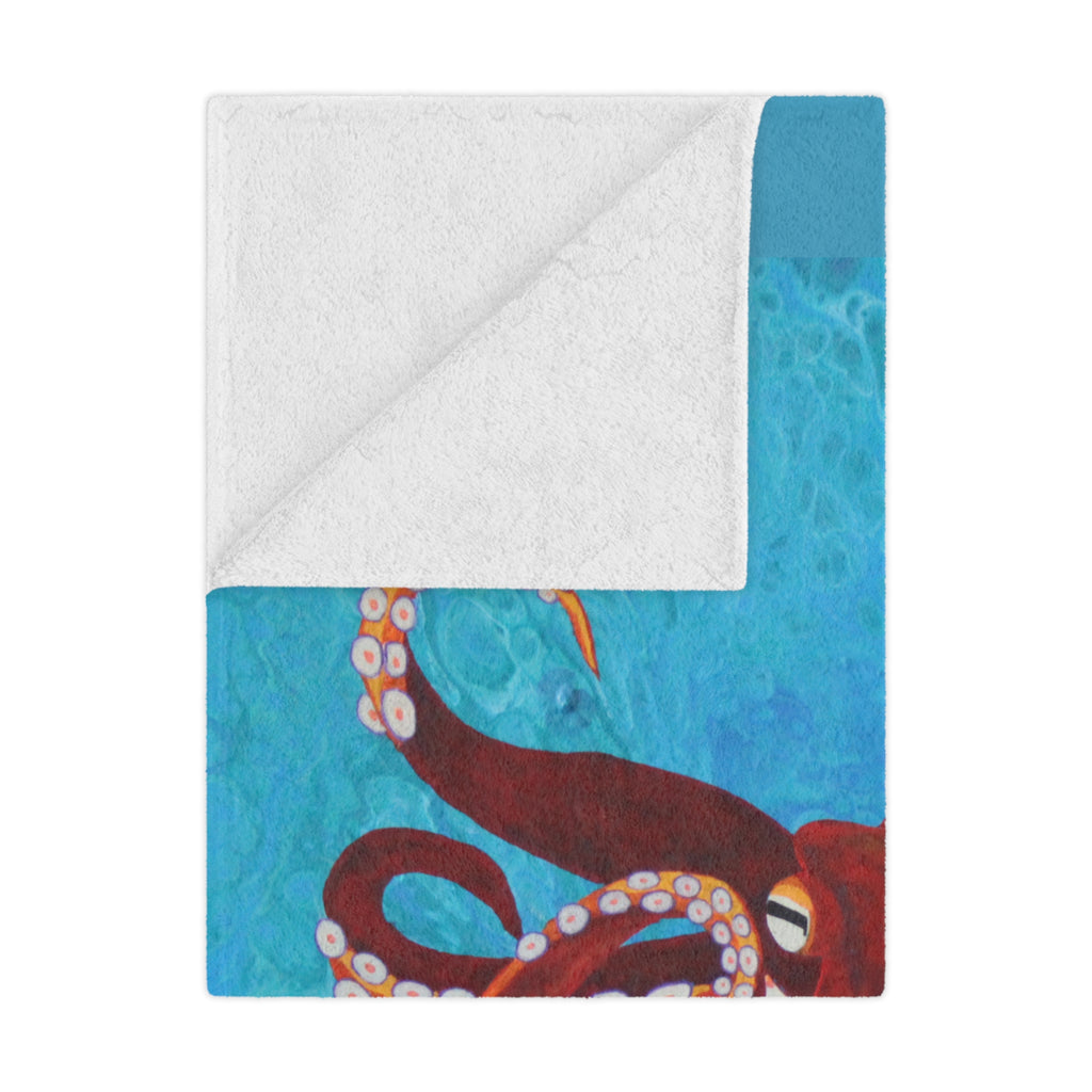 Blanket folded with an octopus design on a blue and white background