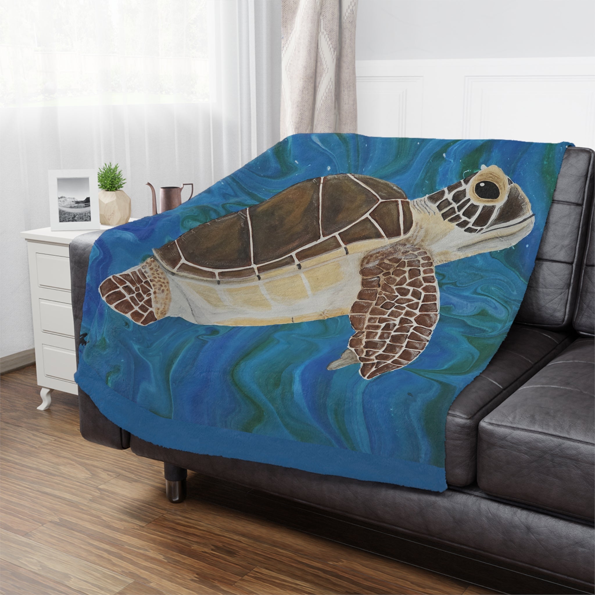 Sofa with a turtle-themed blanket draped over it in a living room setting.