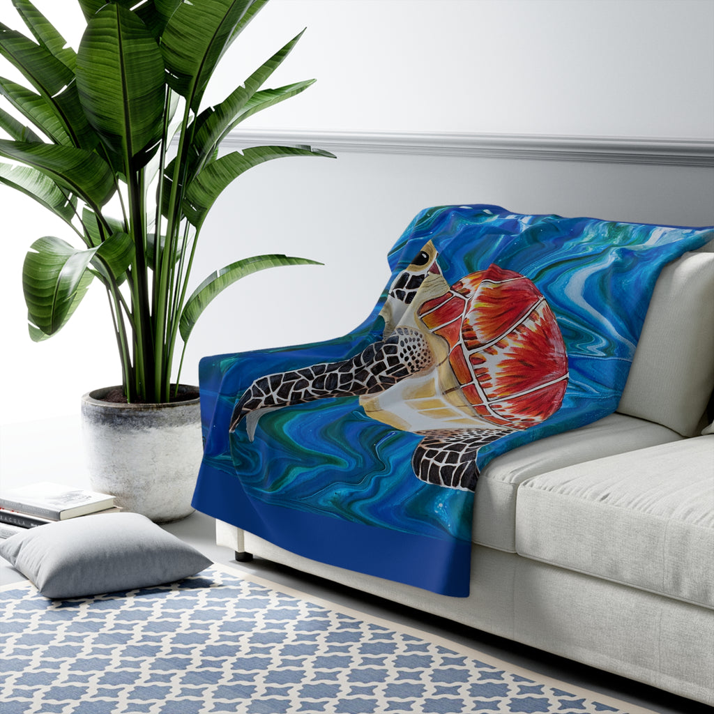 Colorful fish-themed blanket draped over a couch in a living room setting.