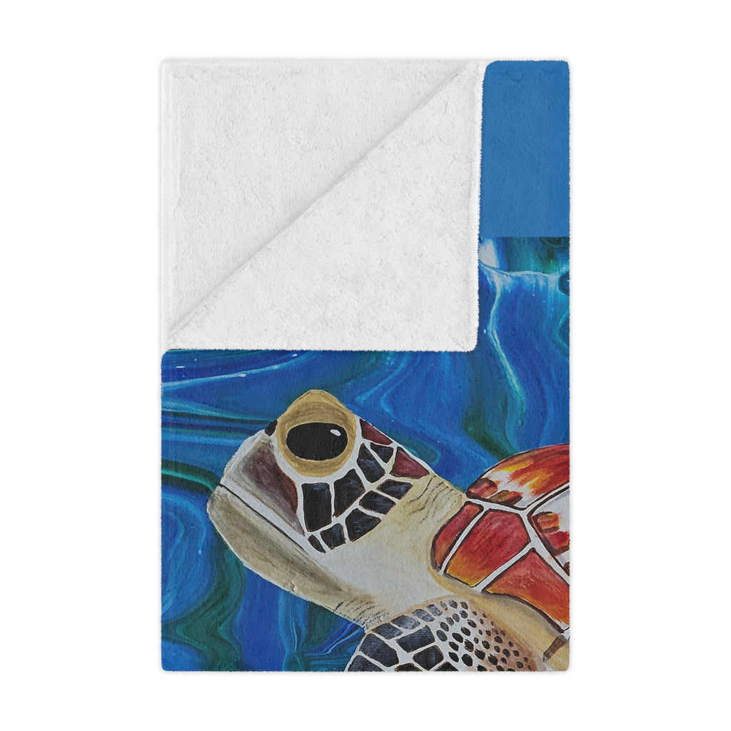 Blanket folded with a turtle design on a blue and white background