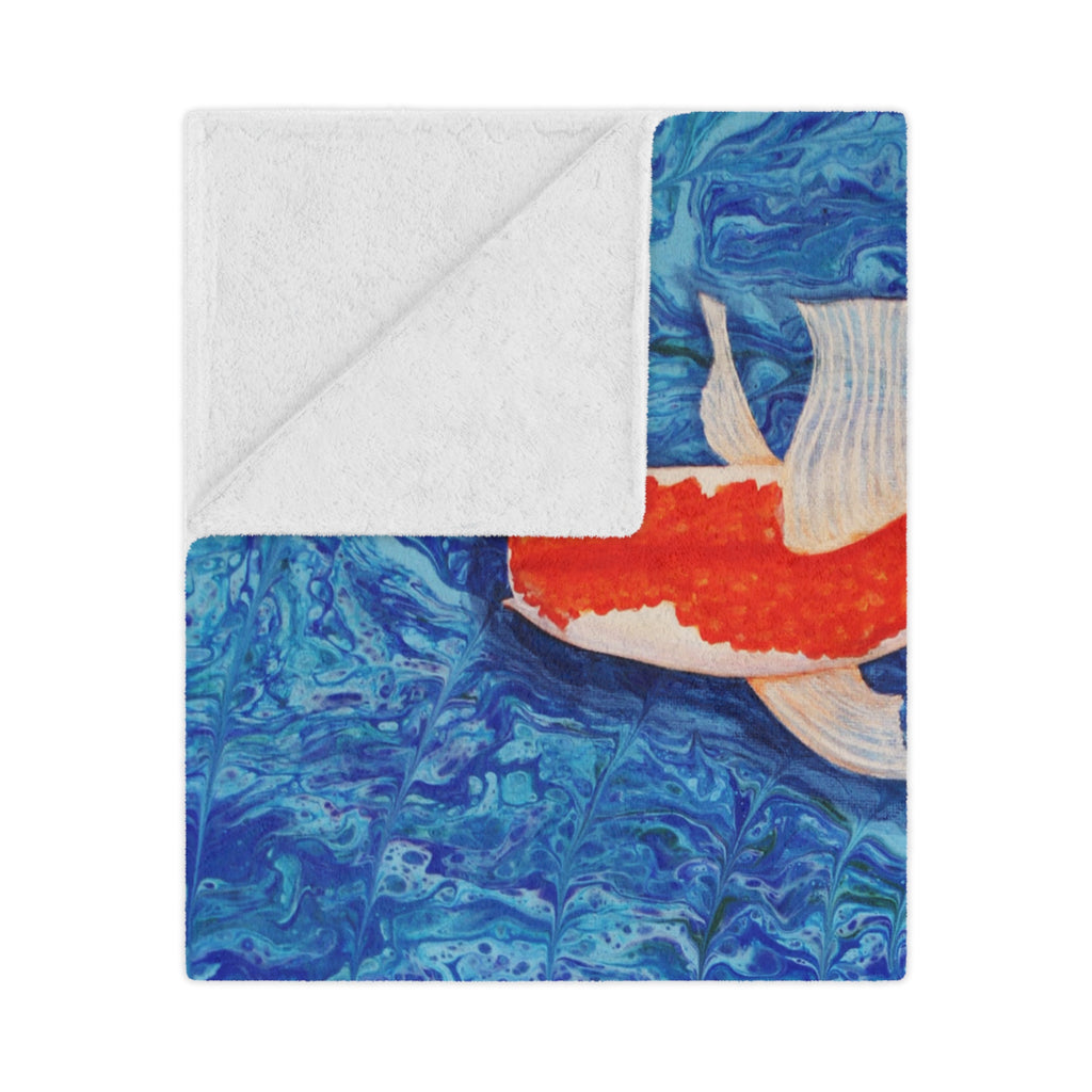 Blanket with a colorful fish design on a blue water pattern