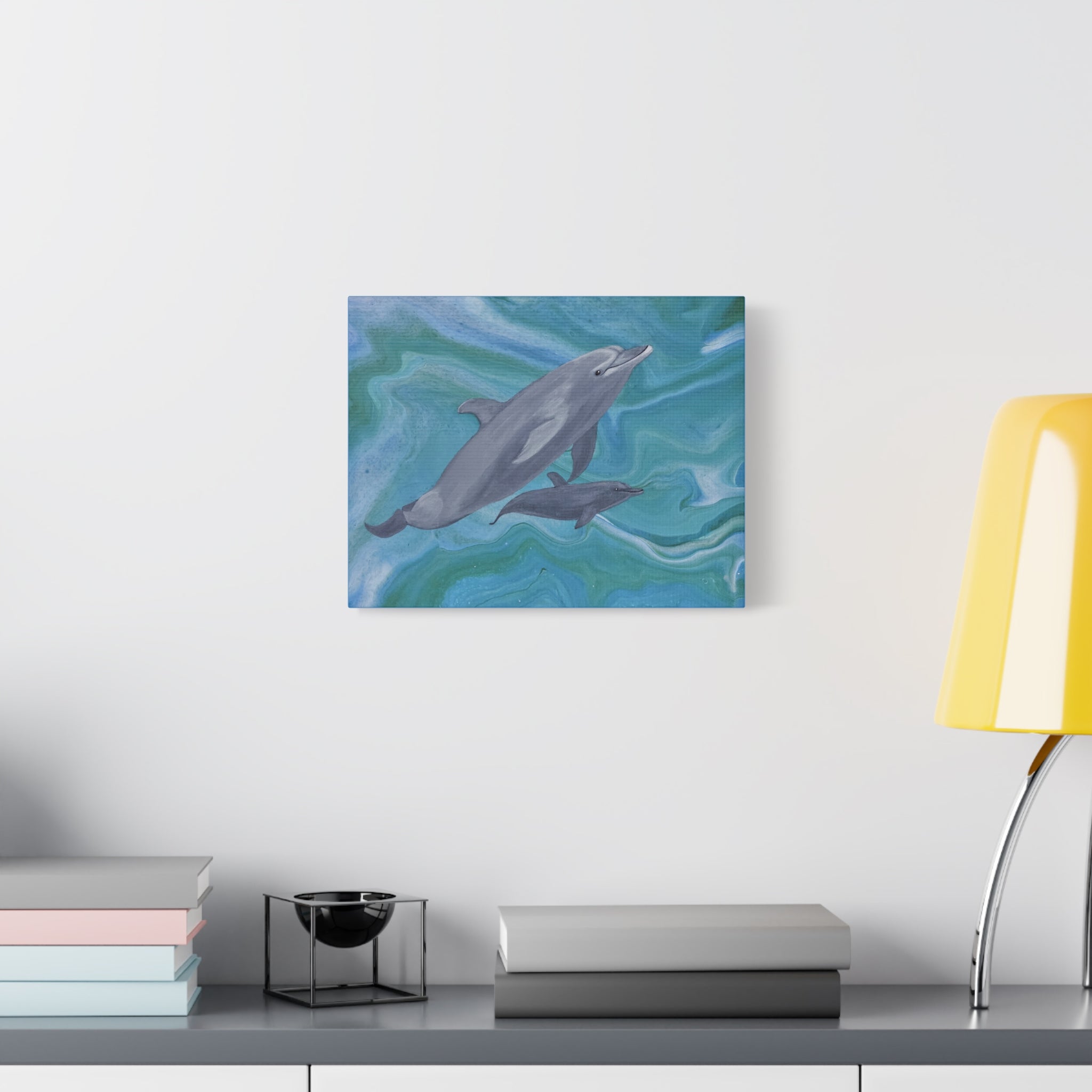 Canvas print of a dolphin on a wall above a desk with books and a lamp.