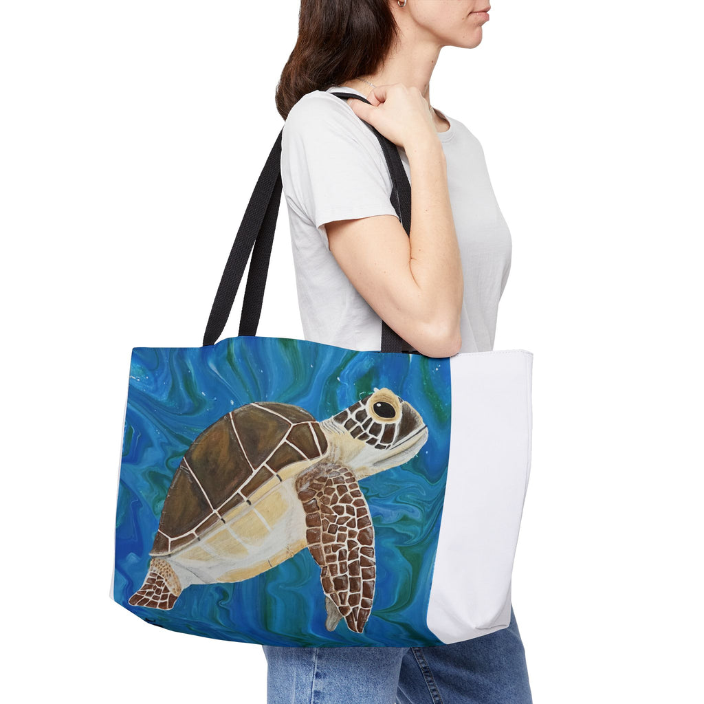 Person holding a tote bag with a turtle design on a white background