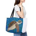 Person holding a tote bag with a turtle design on a white background