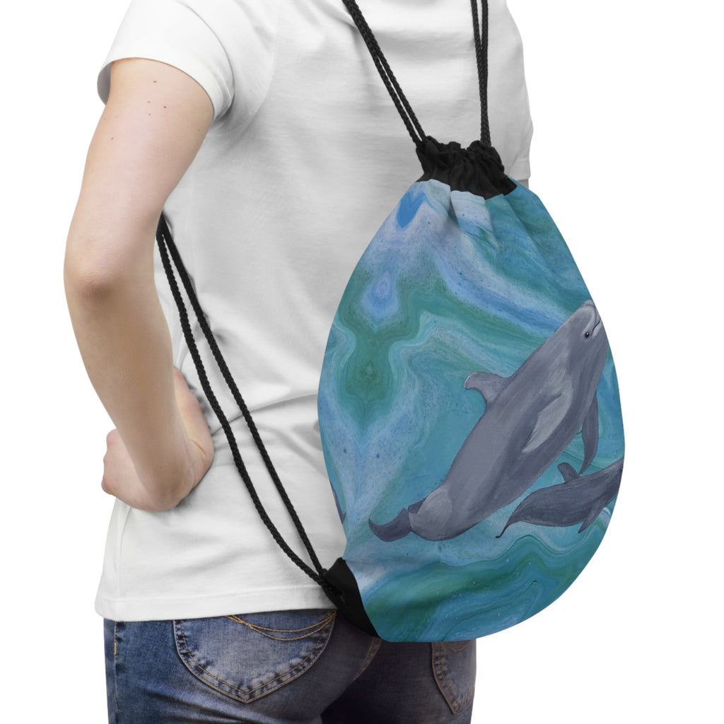 Person wearing a drawstring bag with dolphin design on a white background