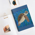 Notebook with a turtle illustration on a white surface