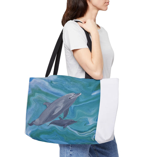 Person holding a tote bag with dolphin design