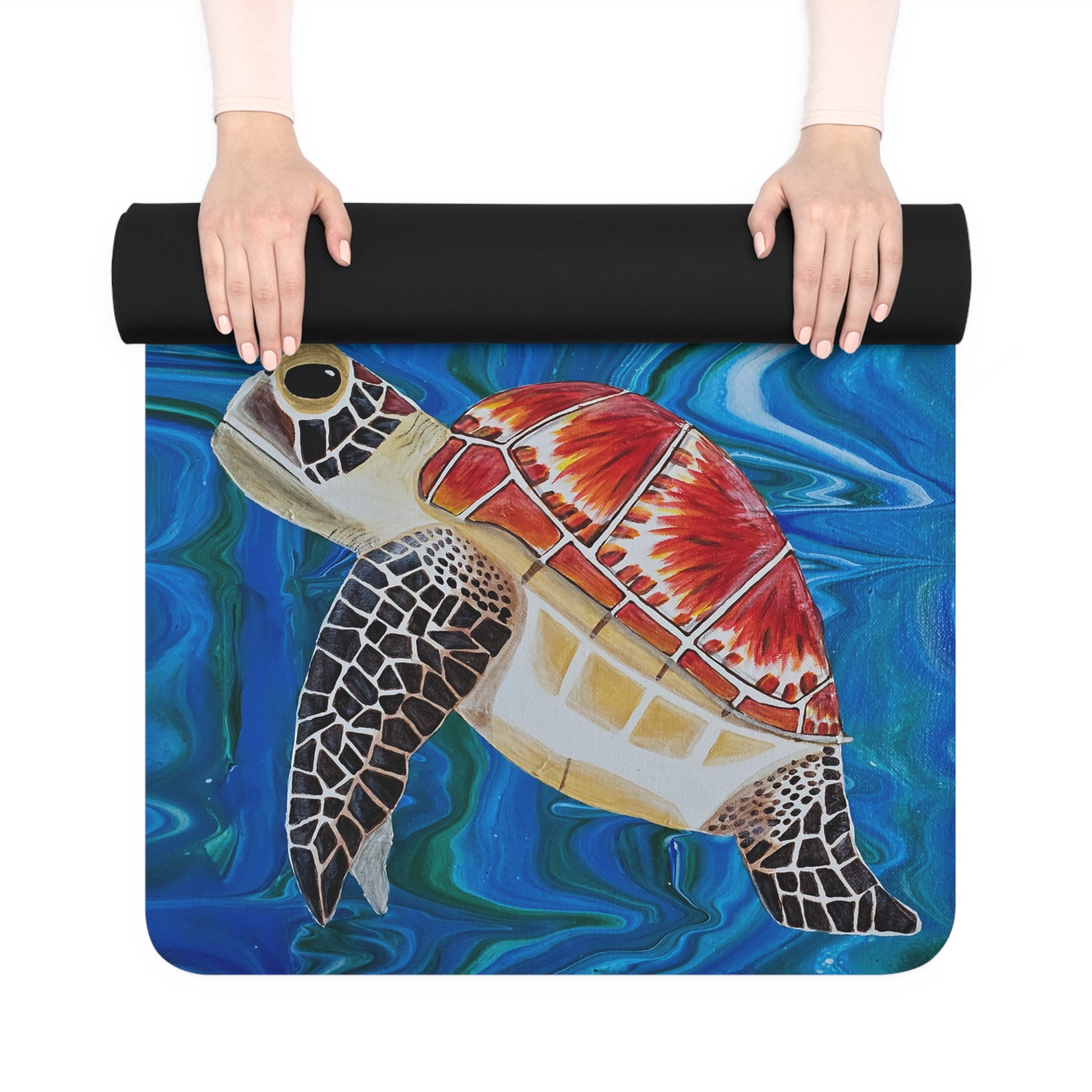 Yoga mat with a turtle design on a blue background, held by two hands.