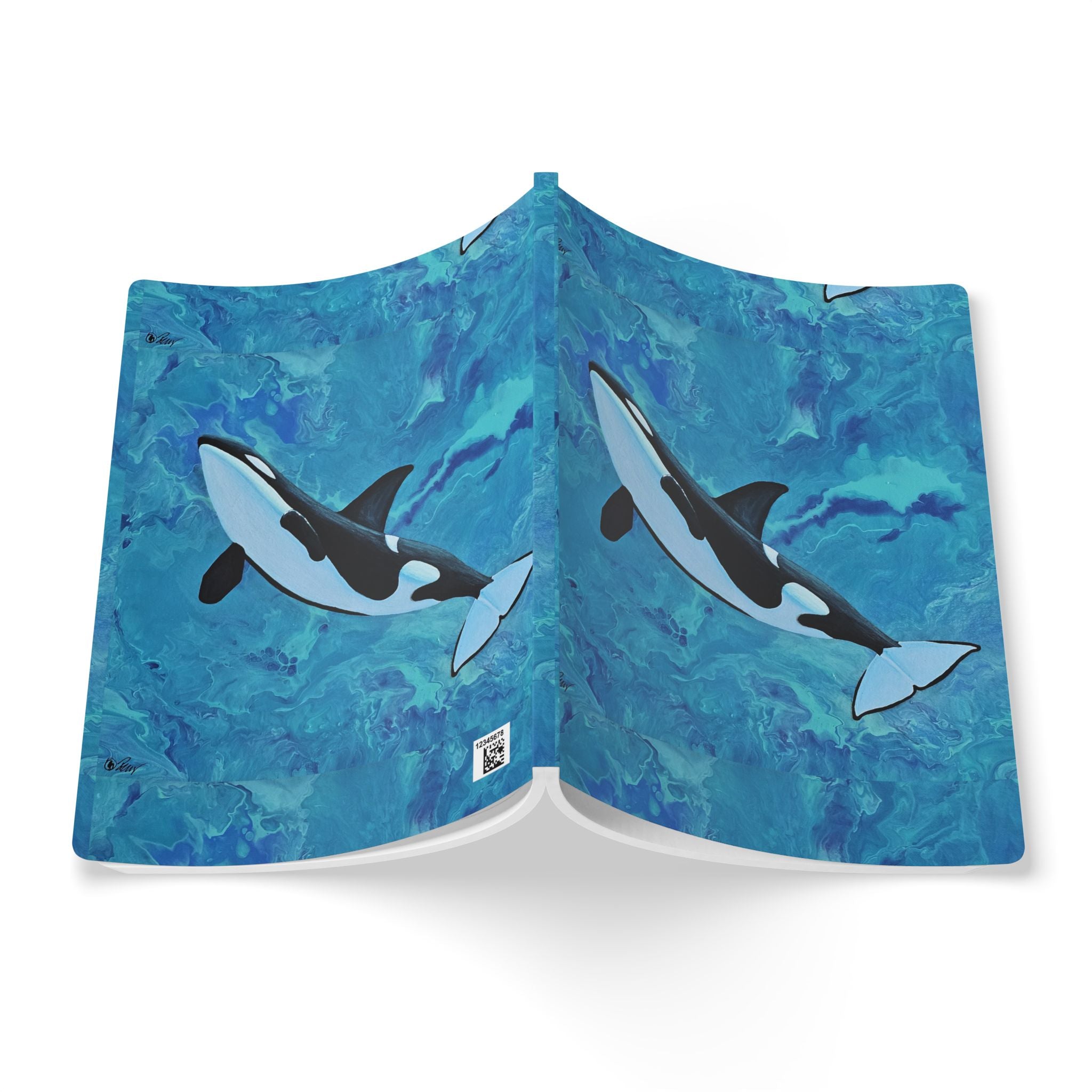 Open notebook with whale illustrations on a blue watercolor background