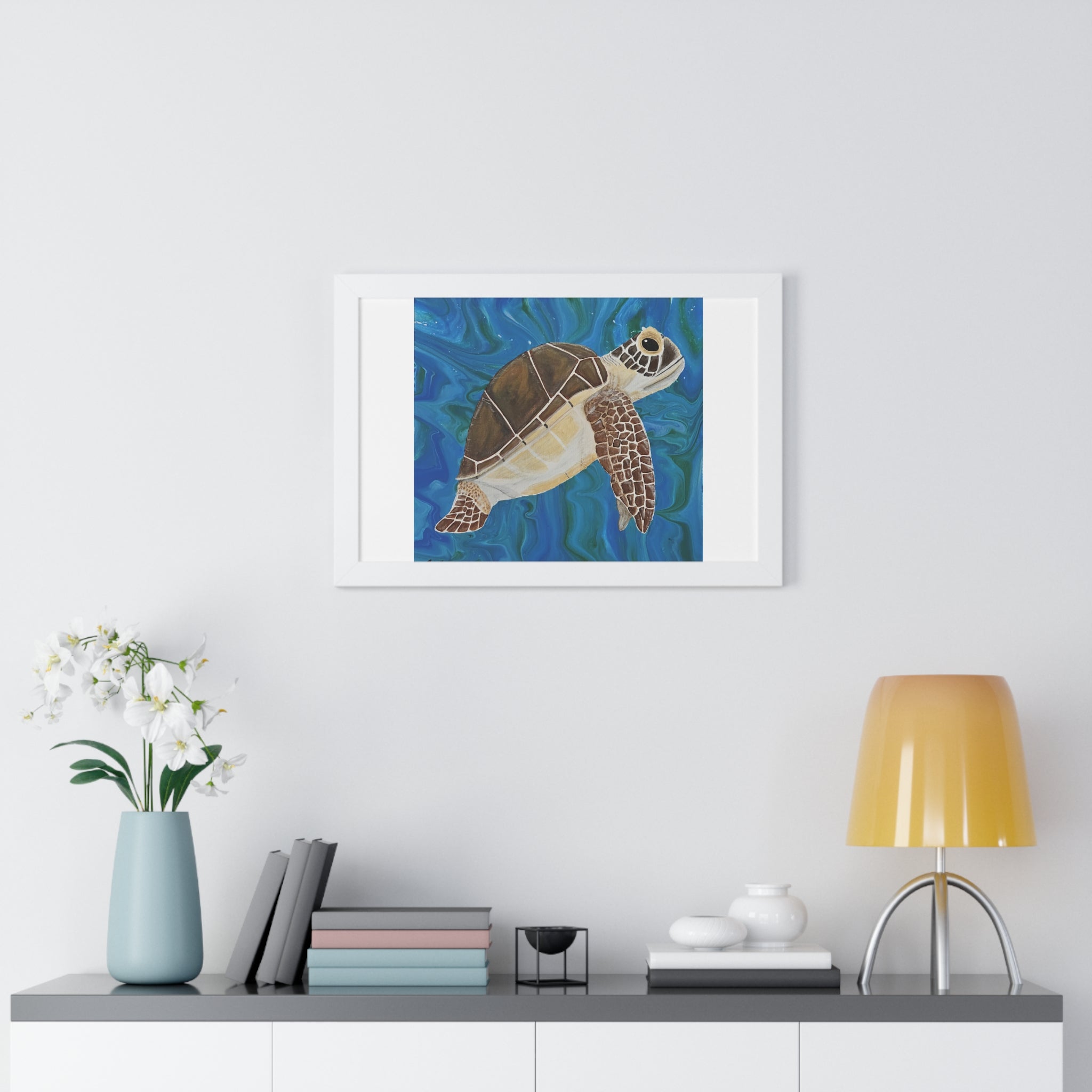 Framed artwork of a turtle on a wall above a shelf with decor items.