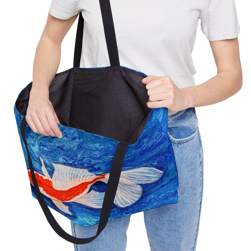 Person holding a tote bag with a fish design on a white background
