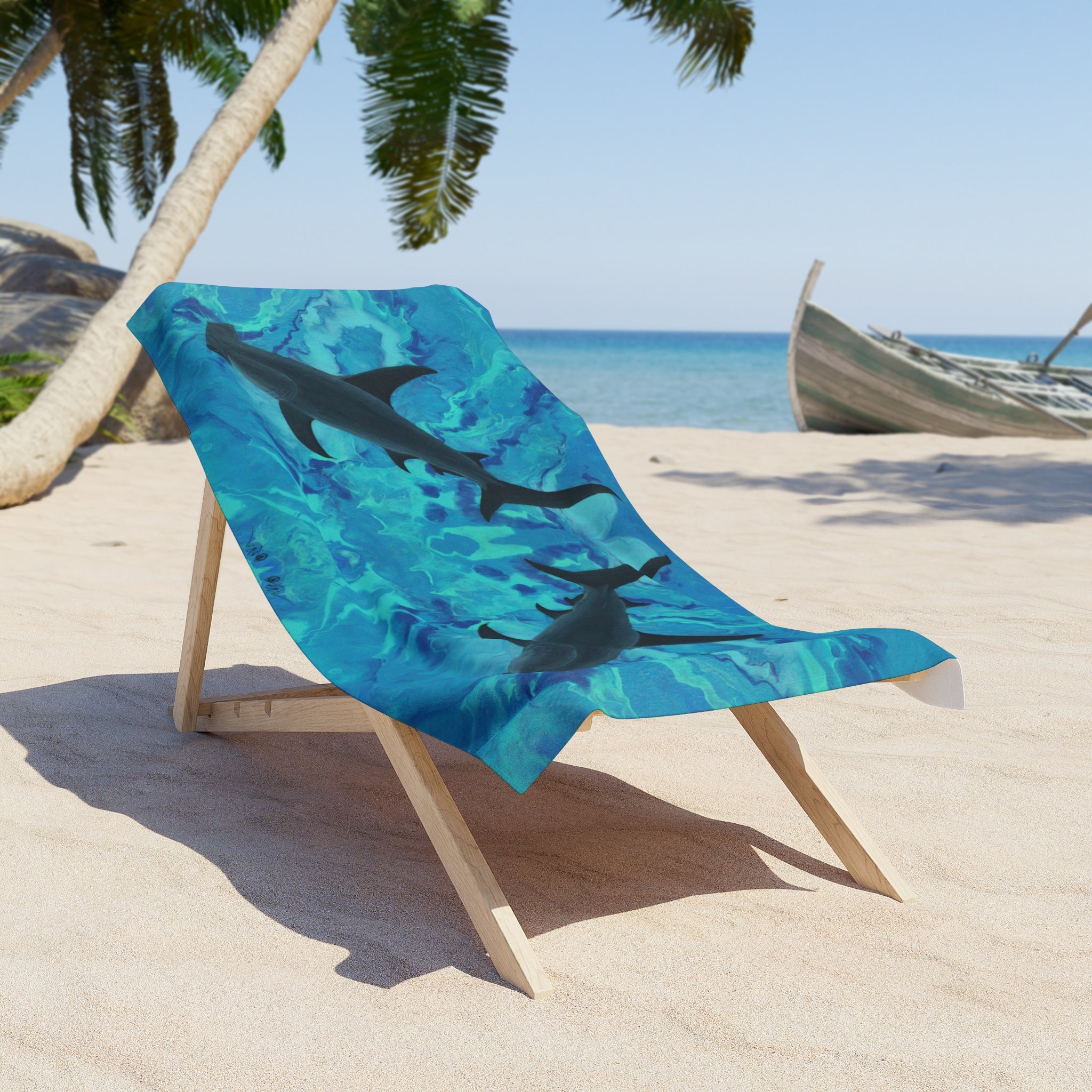 Beach towel/blanket with hammerhead shark design on a wooden chair at a beach.