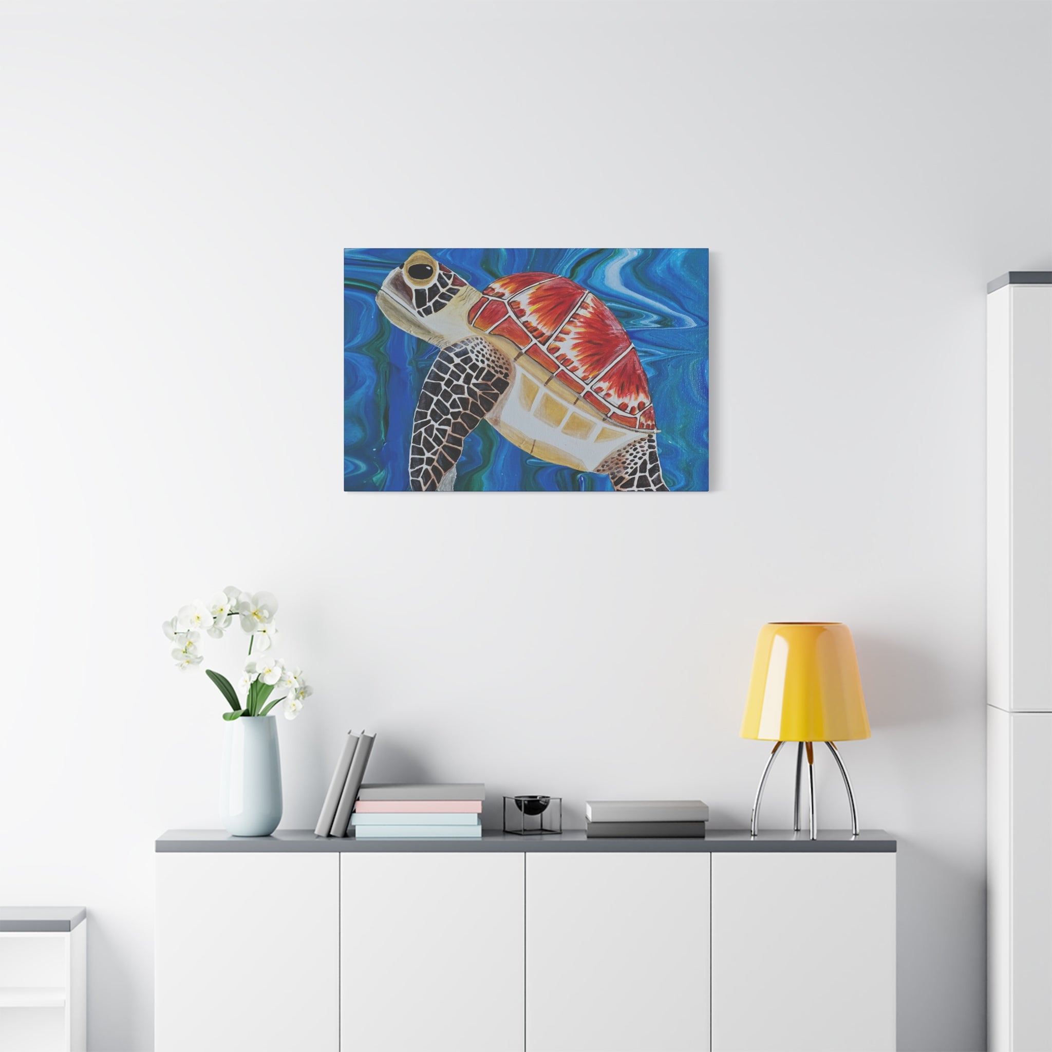 Colorful turtle painting on a white wall above a white cabinet with a yellow lamp.