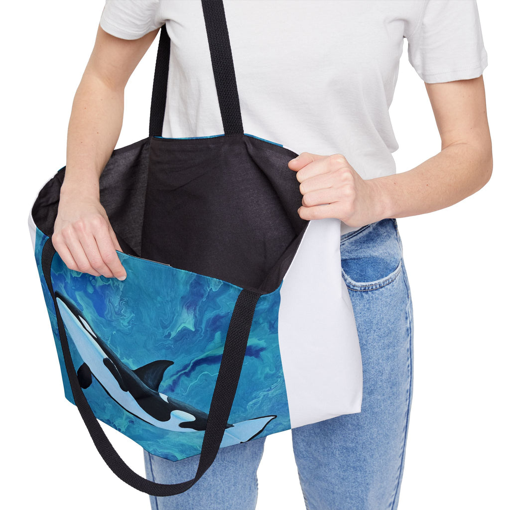 Person holding a tote bag with whale design