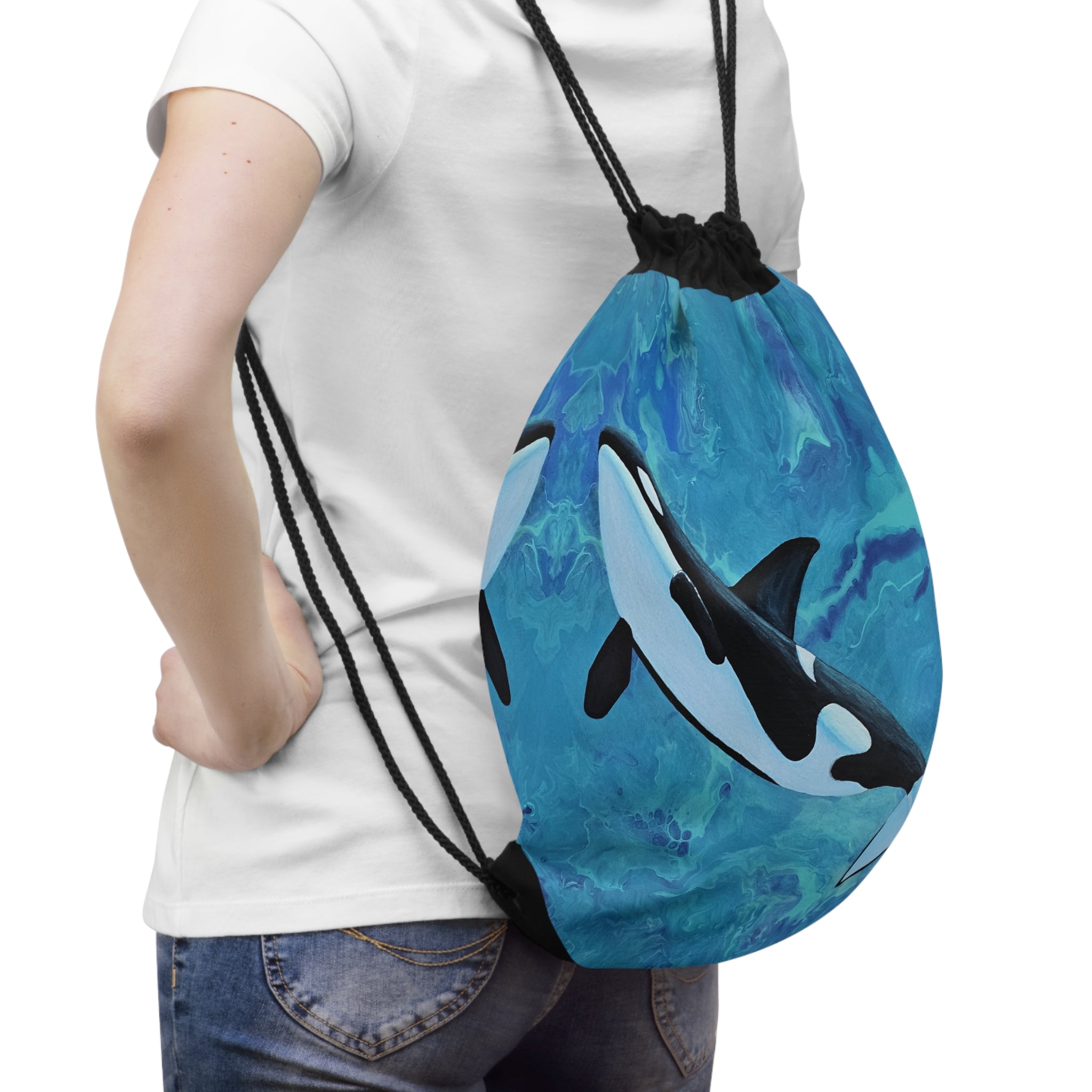 Person wearing a blue drawstring bag with an orca whale design on a white background