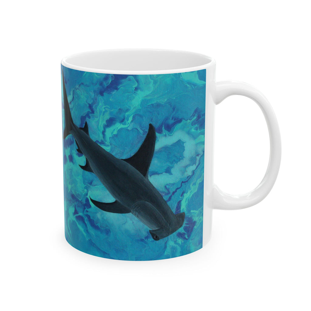 Mug with a design of shark swimming underwater on a blue and green patterned background.