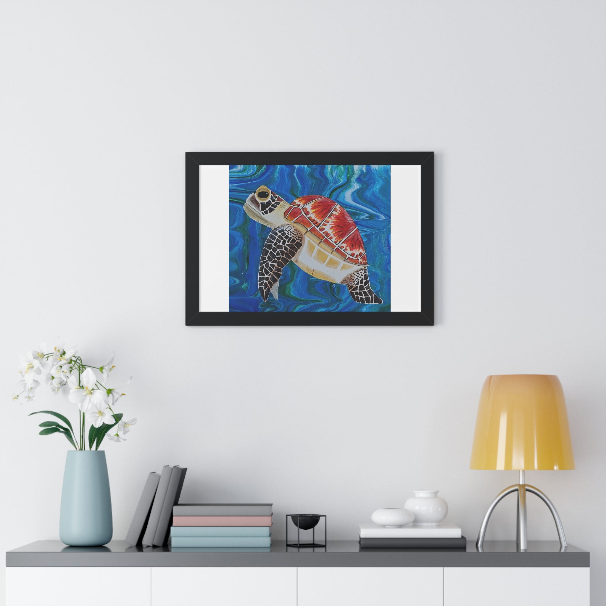 Framed artwork of a turtle on a wall above a shelf with decor items.
