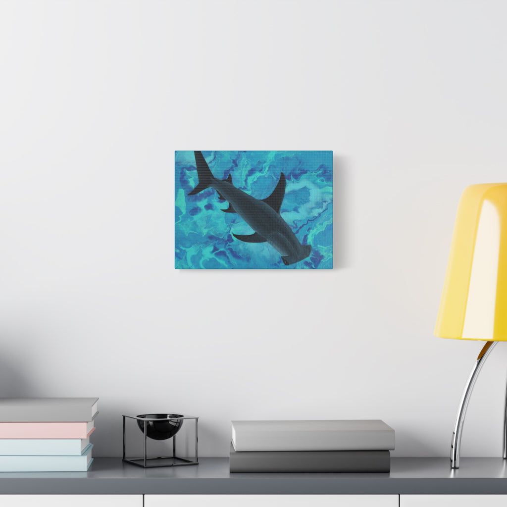 Canvas print of a shark on a blue abstract background hanging on a wall above a desk.