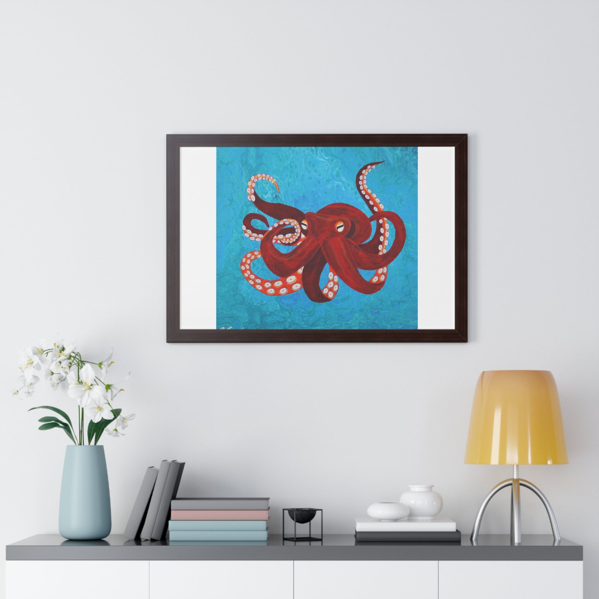 Framed artwork of a red octopus on a blue background above a shelf with decorative items.
