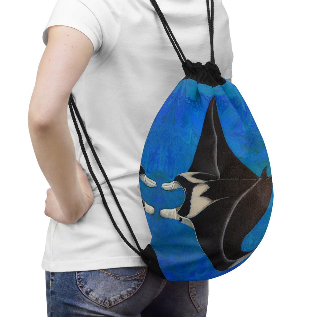 Person holding a blue drawstring bag with a shark design on a white background