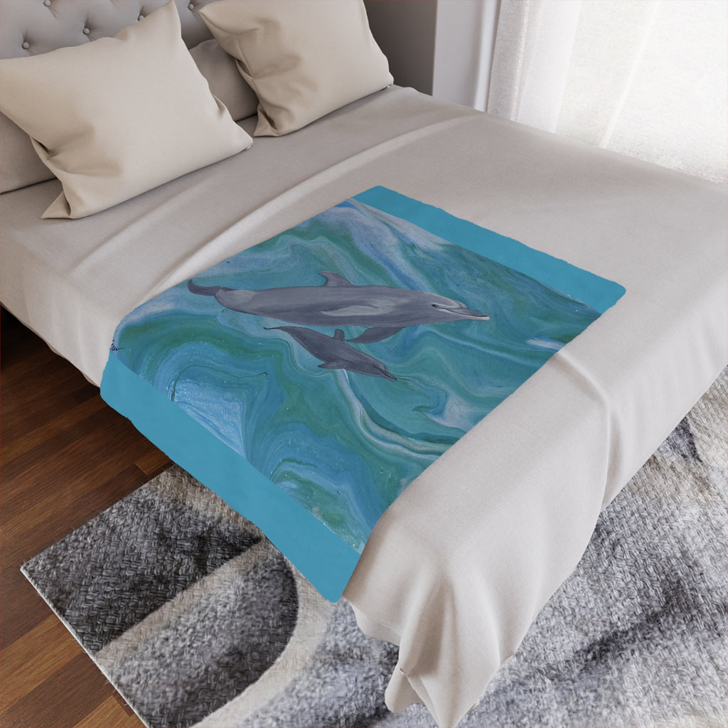 Bed with a dolphin-themed blanket draped over it