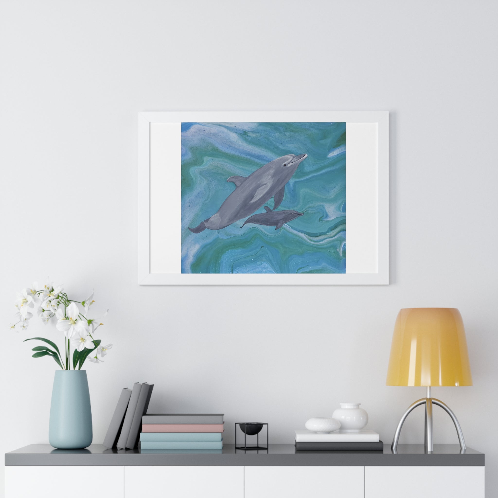 Framed artwork of dolphins on a wall above a shelf with decor items.